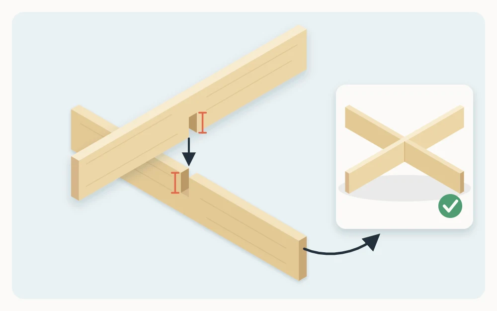 Two thin wooden strips crossing at a right angle with matching notches cut halfway through each so they slot together flush