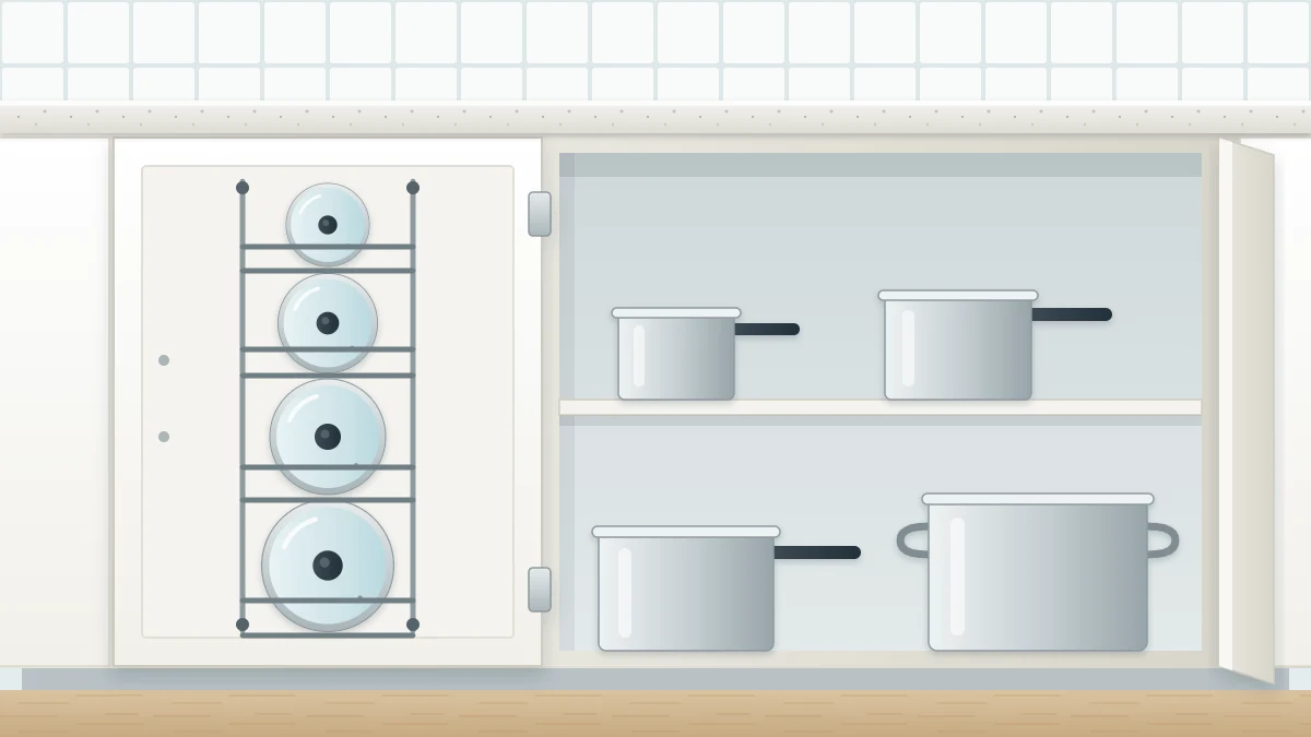 The inside of an open lower cabinet door with a slim wire rack holding four pot lids upright, with matching saucepans on the shelf beside it